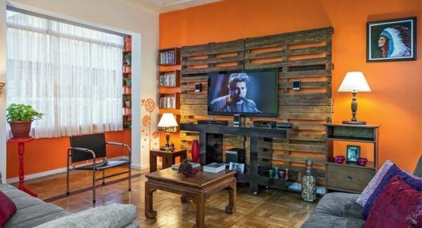 Imagem mostrando sala de casa com painel de TV feito de palete