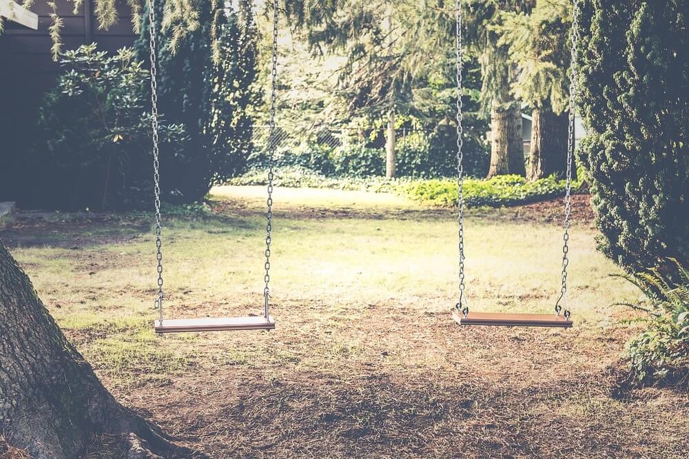 Dois balanços em espaço arborizado